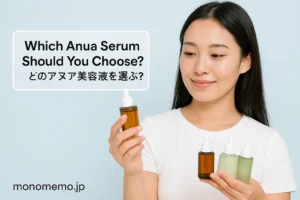 Anua skincare serums, holding multiple dropper bottles while looking at one of them. The background is soft light blue, with the text ‘Which Anua Serum Should You Choose? / どのアヌア美容液を選ぶ？’ on the left and the monomemo.jp logo at the bottom."